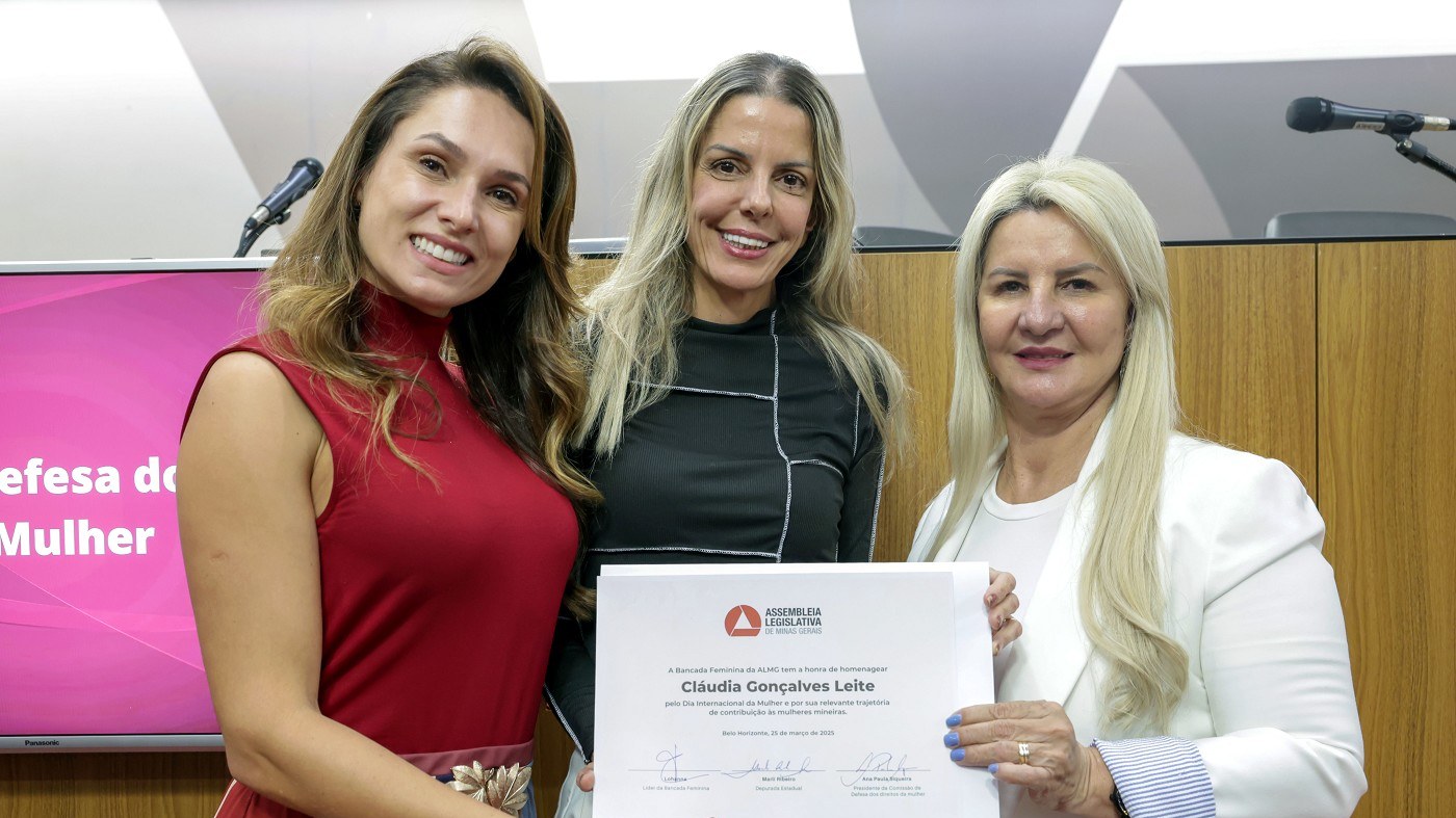 Três mulheres posam com um diploma durante evento da Bancada Feminina da ALMG