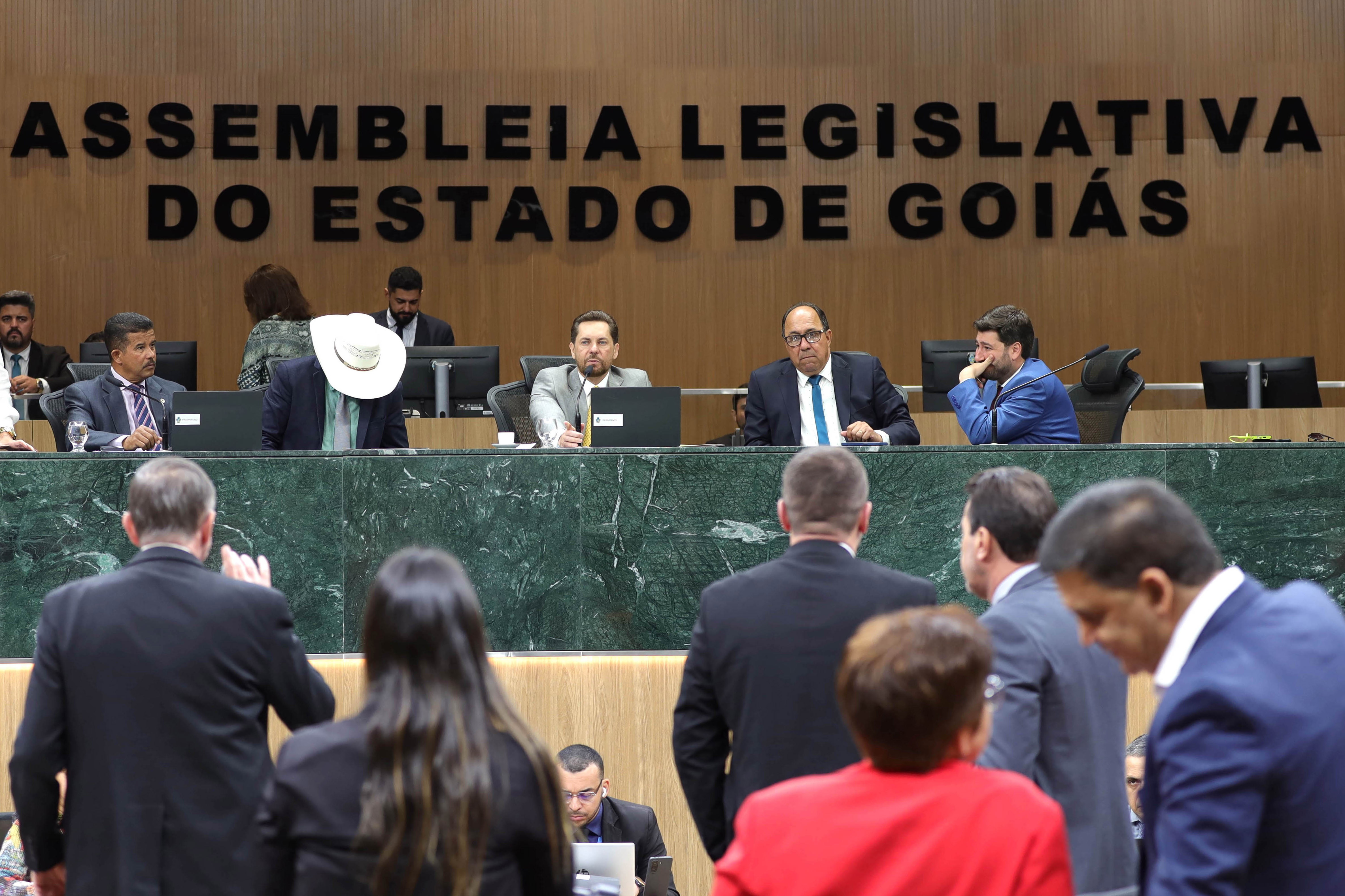 Mesa e deputados no plenário da Assembleia Legislativa de Goiás, no Palácio Maguito Vilela, com a identificação da Casa ao fundo