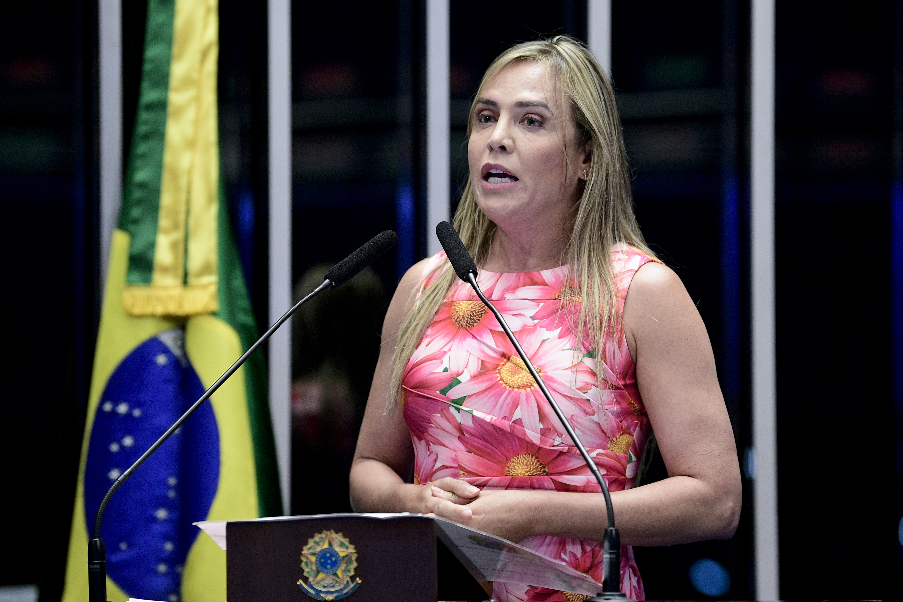 Celina Leão, de vestido estampado de flores rosa, discursa ao microfone na tribuna do Senado