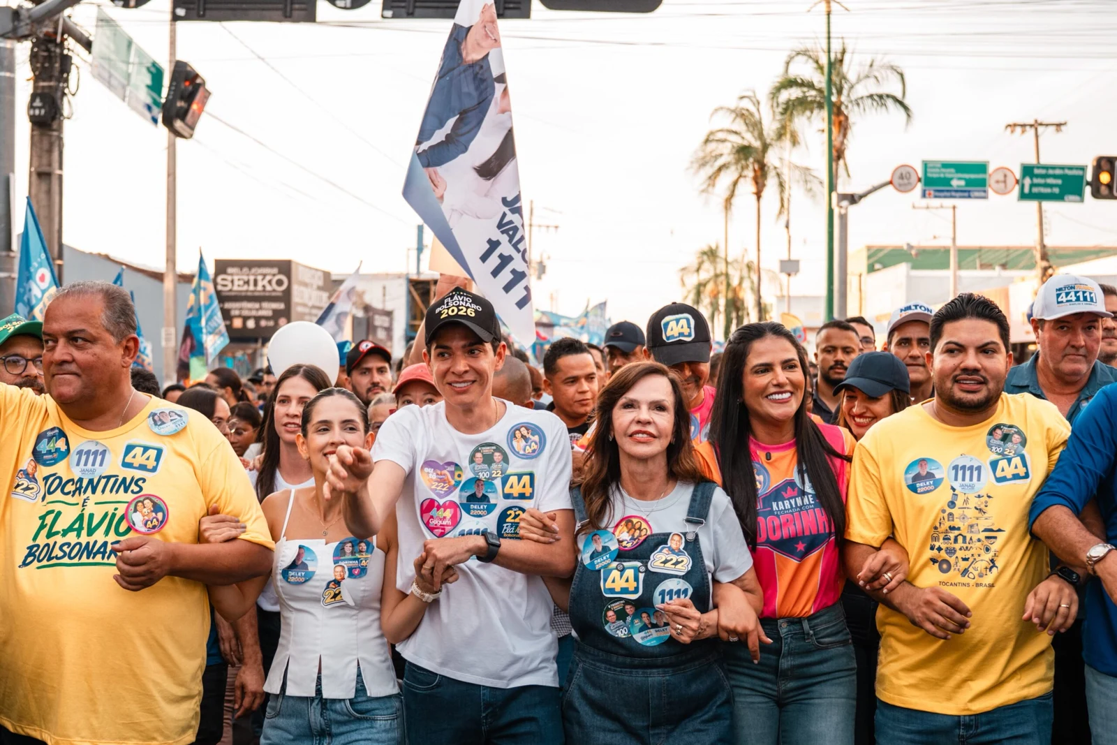 Professora Dorinha, ao centro, de camiseta e jardineira jeans, caminha de braços dados com apoiadores em Paraíso do Tocantins