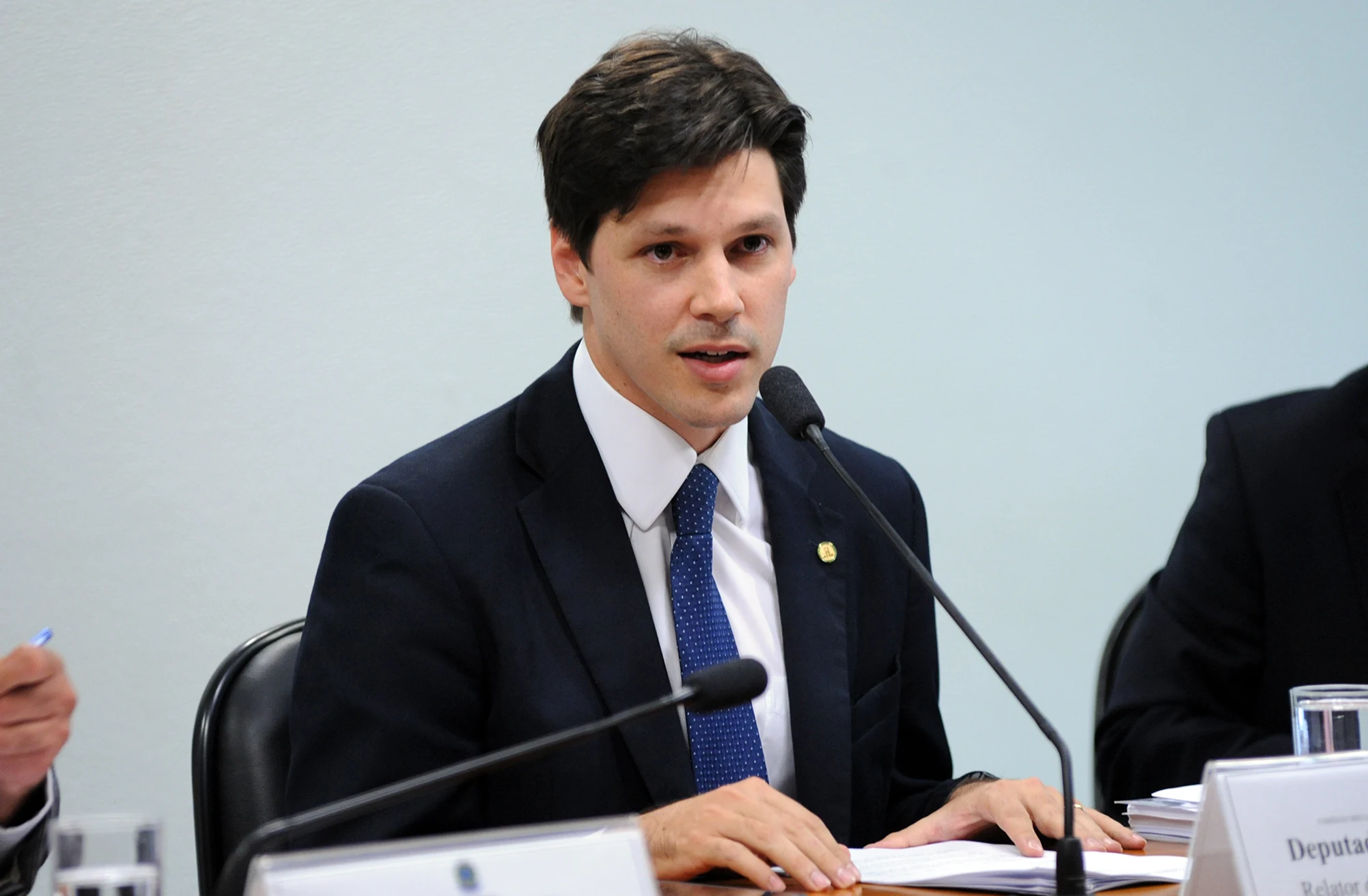 Daniel Vilela, de terno escuro e gravata azul, fala ao microfone sentado à mesa na Câmara dos Deputados